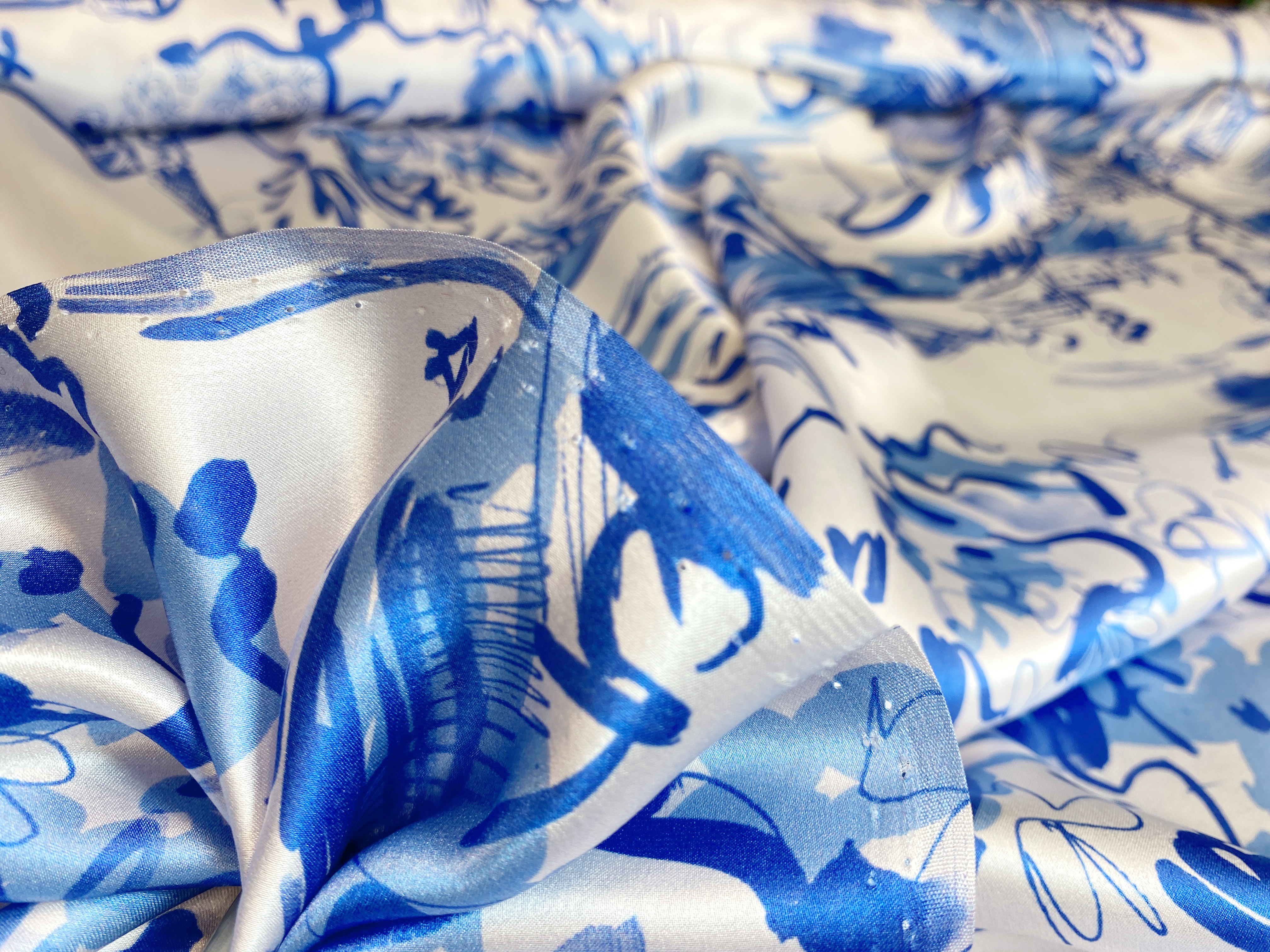 feiner Satin mit blauen Zeichnungen auf weiß